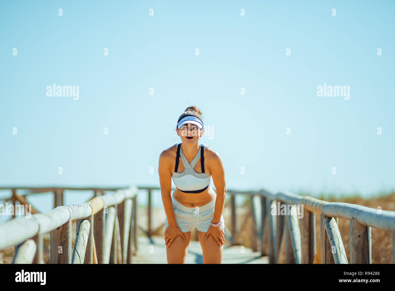 Femme en bonne santé jogger dans fitness vêtements sur la côte prendre souffle après le jogging. C'est ok, pour prendre une pause lorsque vous êtes fatigué. monter debout sur wo Banque D'Images