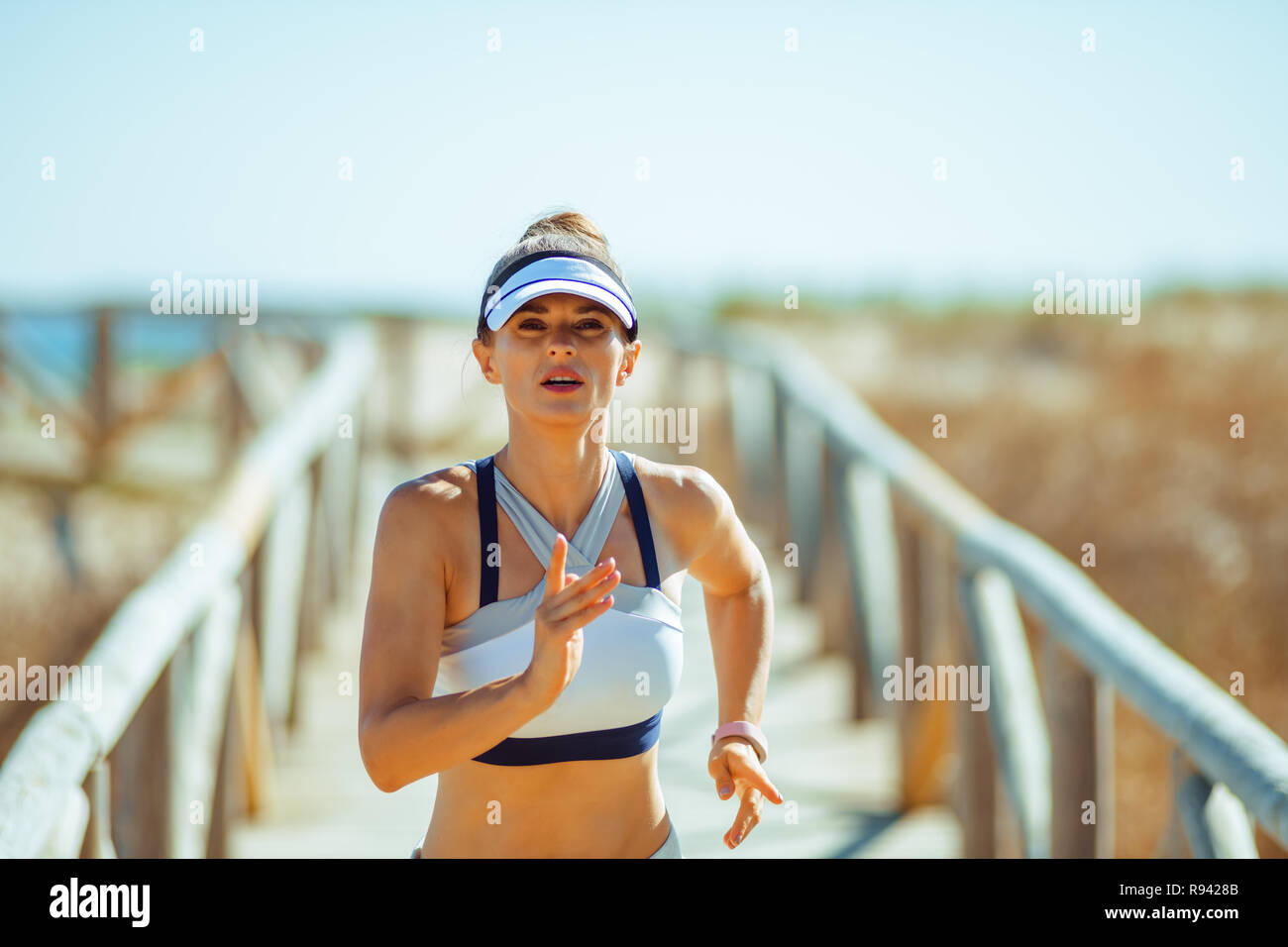 Sports Santé femme en vêtements de sport jogging sur la plage. Vous pouvez vous entraîner n'importe où. Exercice en plein air est l'occasion d'être physiquement actifs Banque D'Images