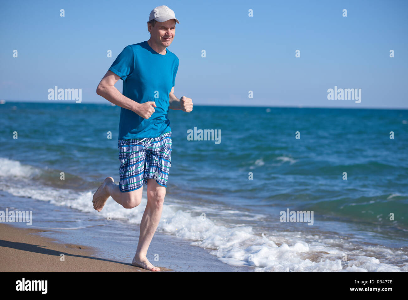 Barefoot man pendant le jogging sur une plage Banque D'Images