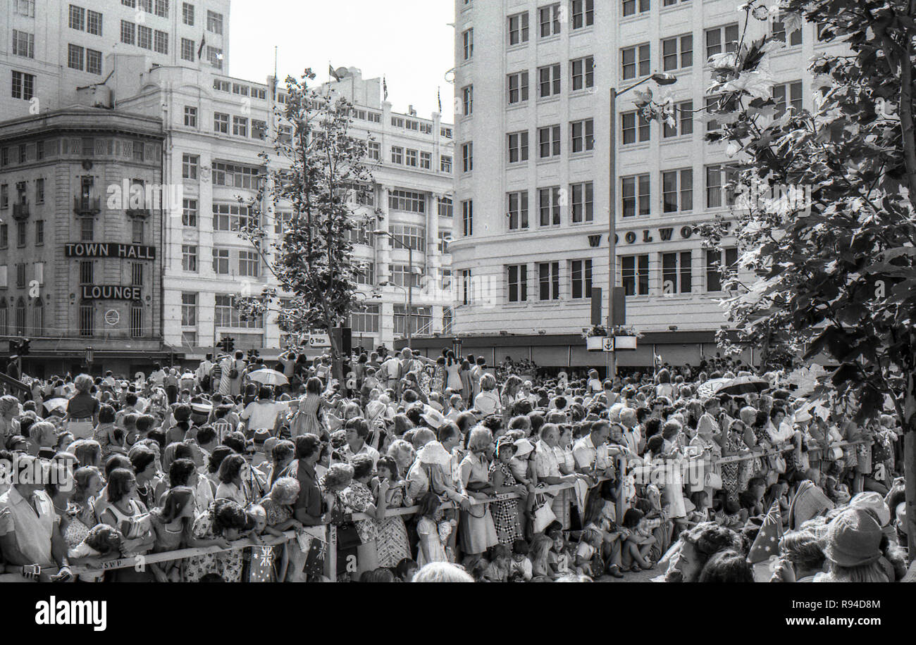 Sydney, Australie, le 13 mars 1977 : des foules de gens de tous âges et des barricades de ligne courbe et applaudir à l'arrivée de la reine Elizabeth II et le prince Philip à Sydney Square près de la Mairie. Le couple royal a assisté à une réception officielle avec le maire de la ville, et plus tard un port Leo à la proximité de la cathédrale de St Andrews. Sa Majesté et le Prince ont été visite de Sydney ainsi que de nombreuses autres parties de l'Australie au cours du mois de mars dans le cadre de leur tournée mondiale Jubilé d'argent. Crédit photo Stephen Dwyer (17 ans) Banque D'Images