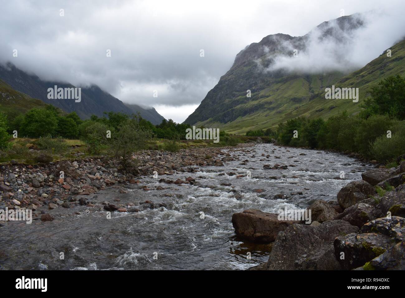 La rivière qui coule à travers la vallée de l'Europe de la chaîne de montagnes Glencoe dans les Highlands écossais. Pris sur un ciel couvert et pluie d'août 24. Banque D'Images