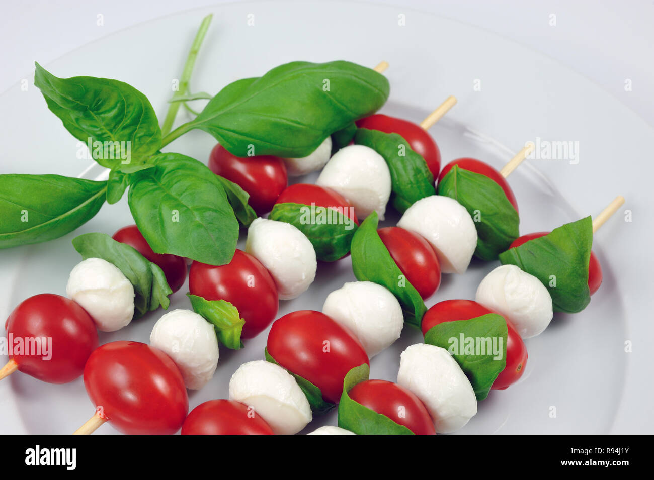 Quatre baguettes fraîches avec tomates cerises, mozzarella et basilic italien Banque D'Images
