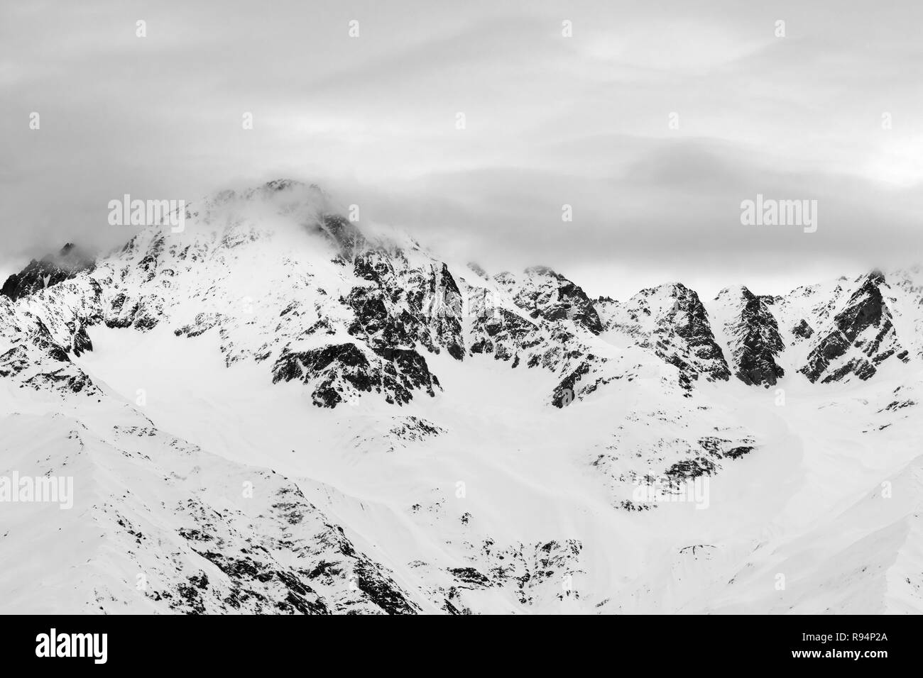 Le noir et blanc des montagnes de neige et ciel nuageux ciel gris avant de neige. Montagnes du Caucase à l'hiver, Svaneti, région de la Géorgie. Banque D'Images