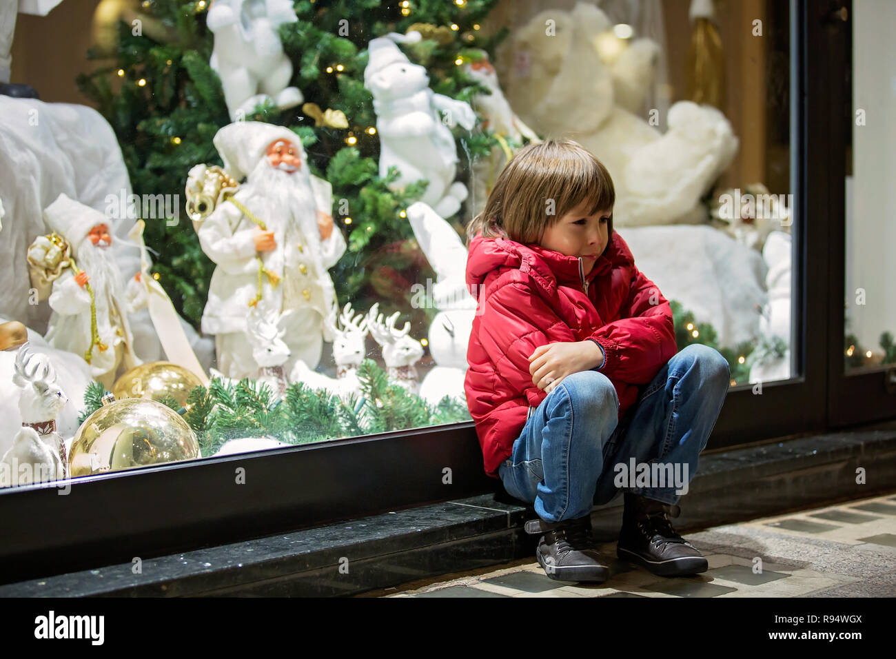 Belle petite enfant, garçon, regarder la décoration de Noël avec des jouets  dans une vitrine d'affichage, qui souhaitent pour un présent, son reflet  dans la fenêtre Photo Stock - Alamy