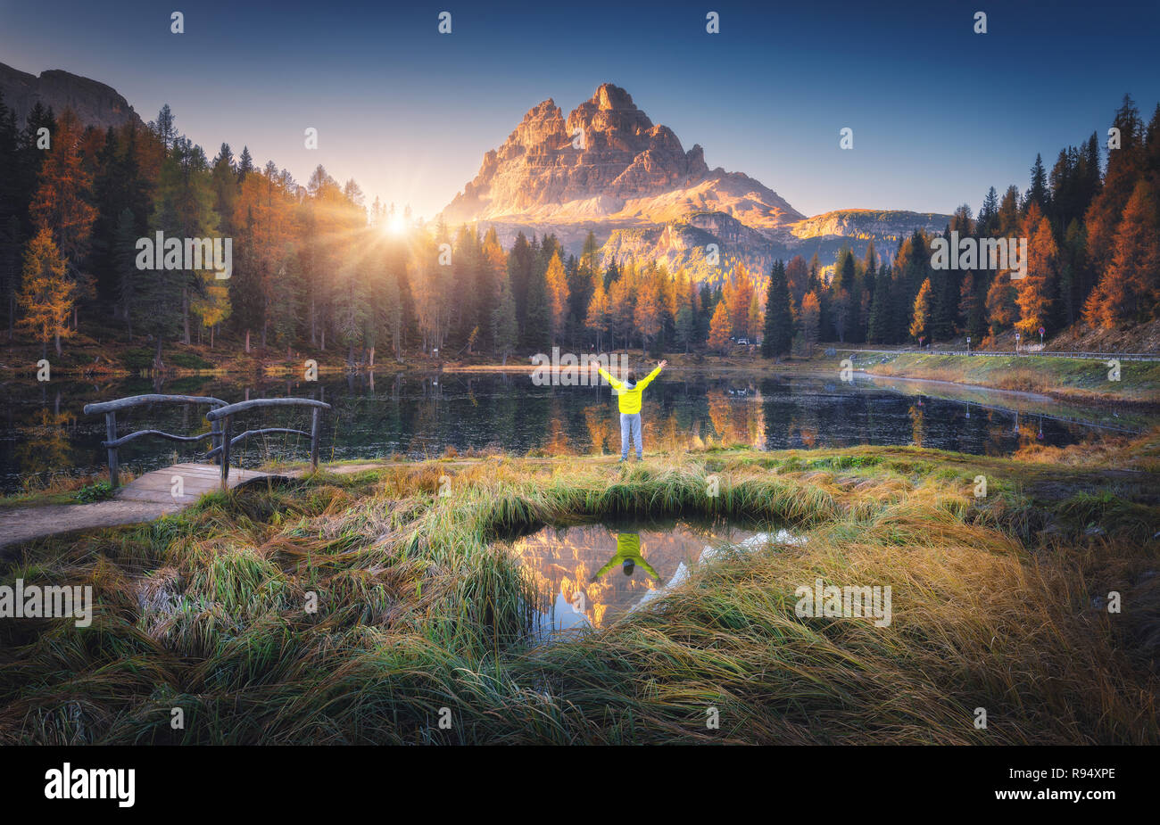 L'homme avec les armes sur Antorno lake avec la réflexion des Tre Cime di Lavaredo au lever du soleil à l'automne en Dolomites, Italie. Paysage avec homme heureux, gr Banque D'Images