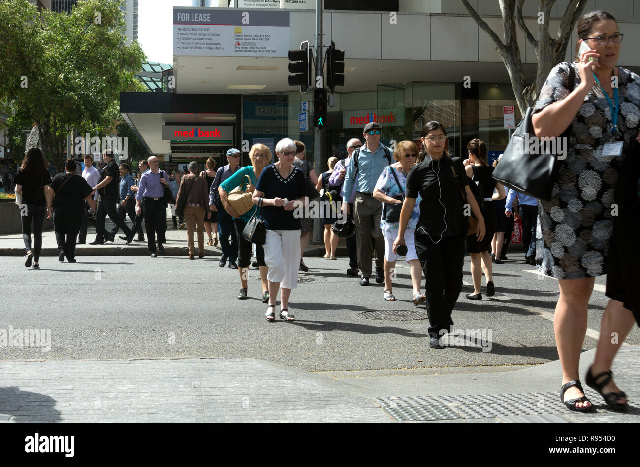 Matin, les navetteurs à un passage pour piétons à Adelaide Street, centre-ville de Brisbane, Queensland, Australie Banque D'Images