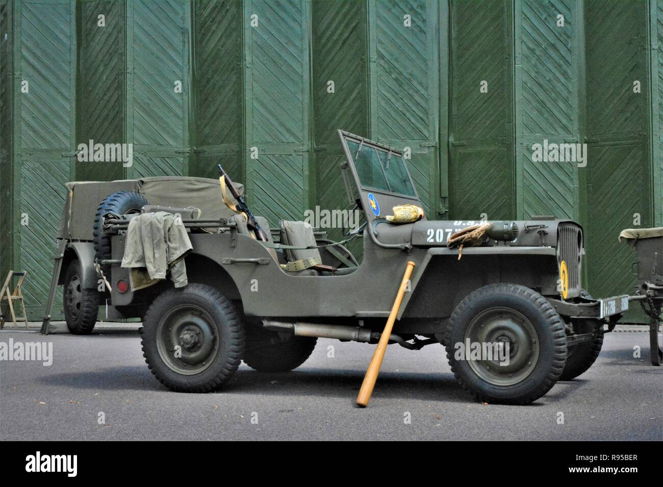 World War 2 jeep de l'armée avec batte de baseball à l'extérieur d'un hanger Banque D'Images