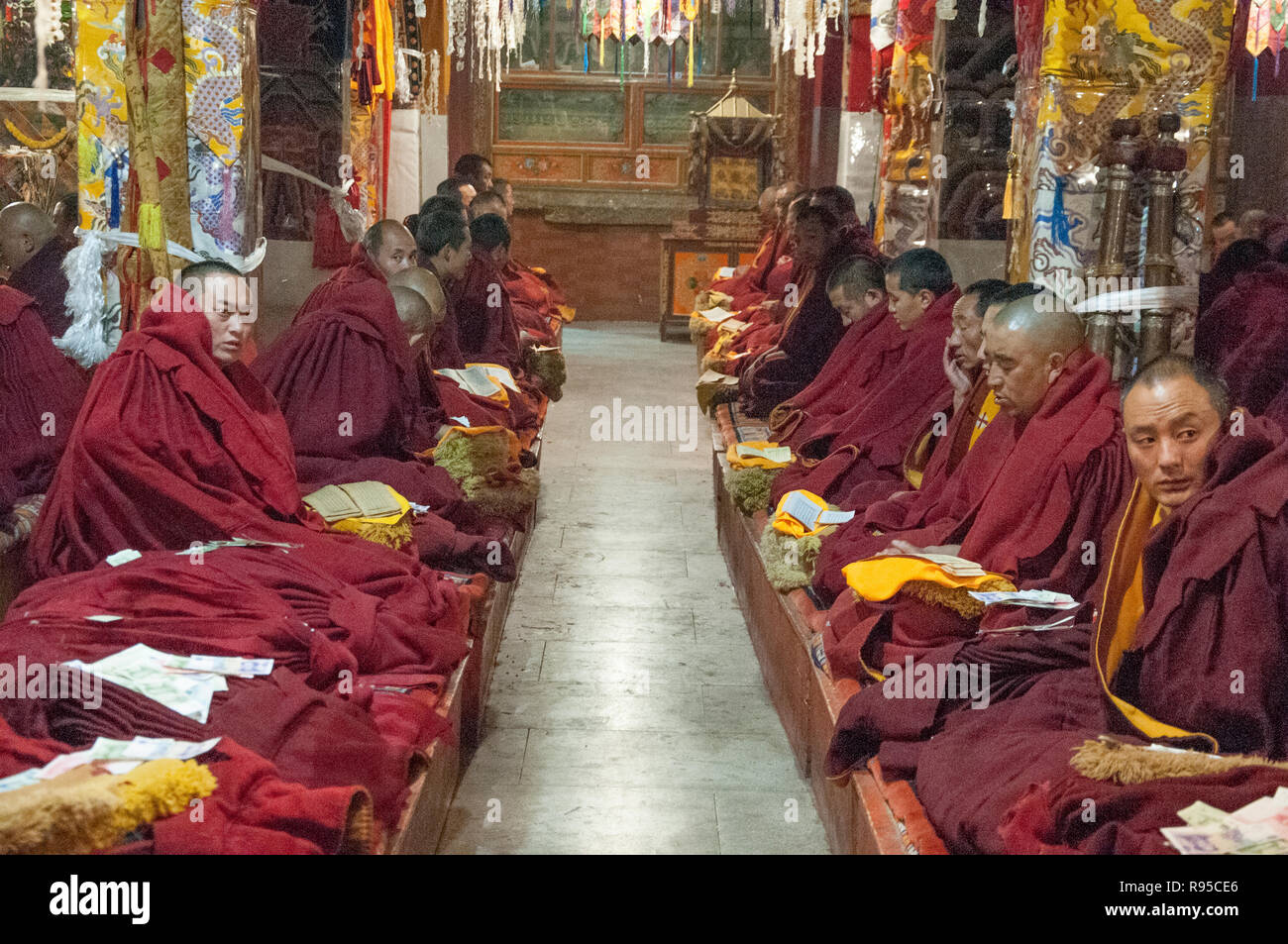Les moines récitent leurs écritures dans le hall principal du monastère de Ganden, l'extérieur de Lhassa, Tibet, Chine Banque D'Images