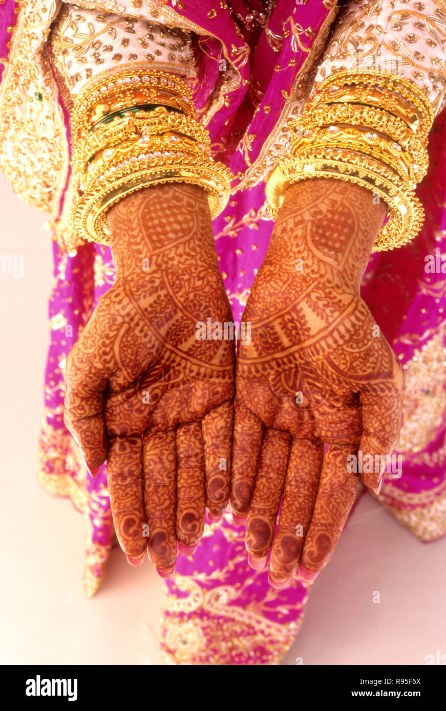 Mains de la mariée avec des bracelets de méhndi et d'or Banque D'Images