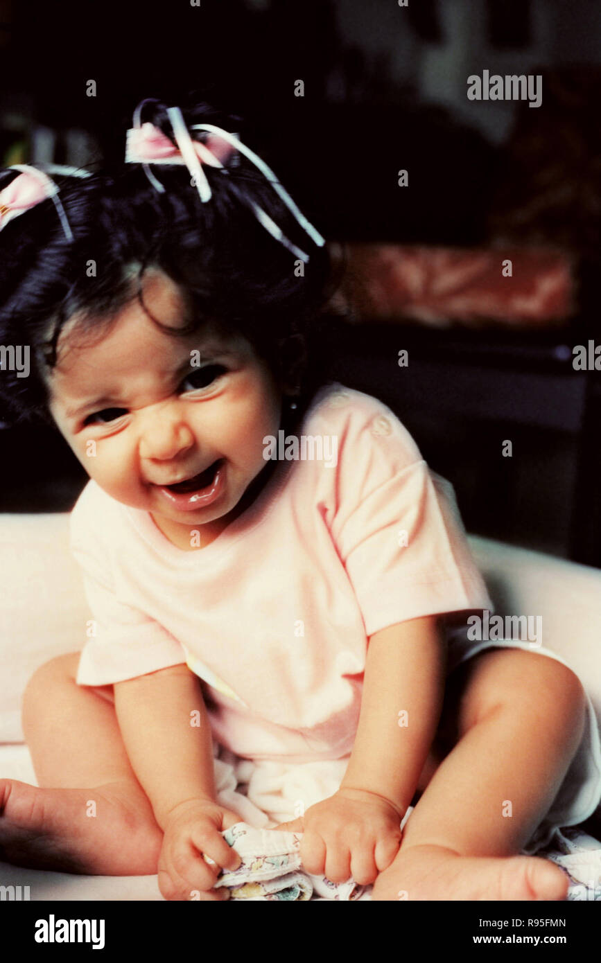 Petite fille enfant assis faisant des visages bizarres Banque D'Images