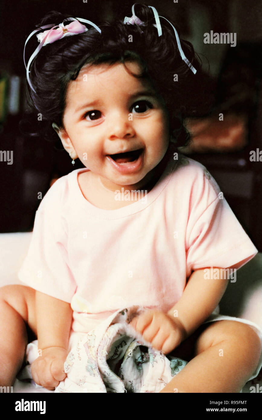 Petite fille enfant assis faisant des visages bizarres Banque D'Images