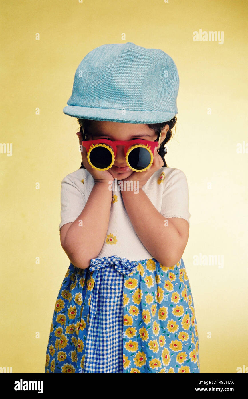 Fille enfant portant des lunettes et un bonnet bizarres Banque D'Images