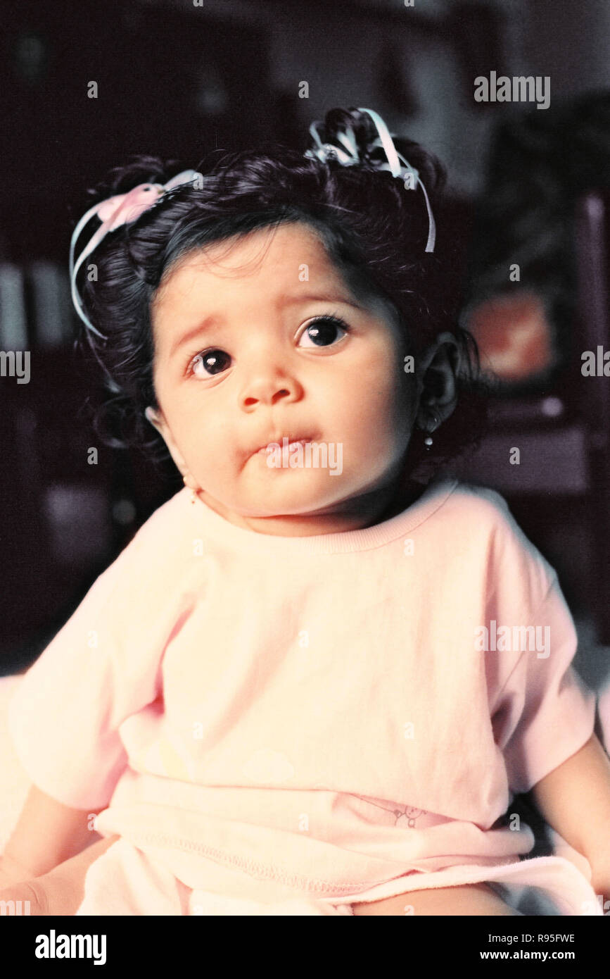 Baby Girl sitting, looking up - MR Banque D'Images