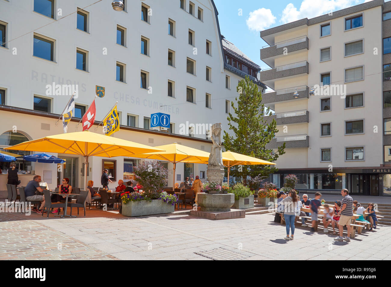SANKT MORITZ, Suisse - le 16 août 2018 : Centre Ville avec trottoir tables, parasols jaunes et des personnes dans un jour d'été ensoleillé à Sankt Moritz, Suisse Banque D'Images