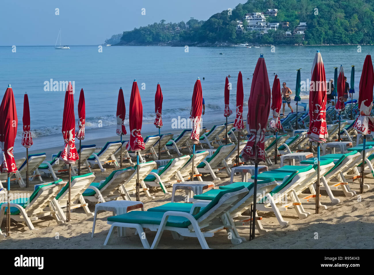 Chaises longues et parasols, encore non ouvert sur un matin tôt à Kamala Beach, Phuket, Thailand Banque D'Images