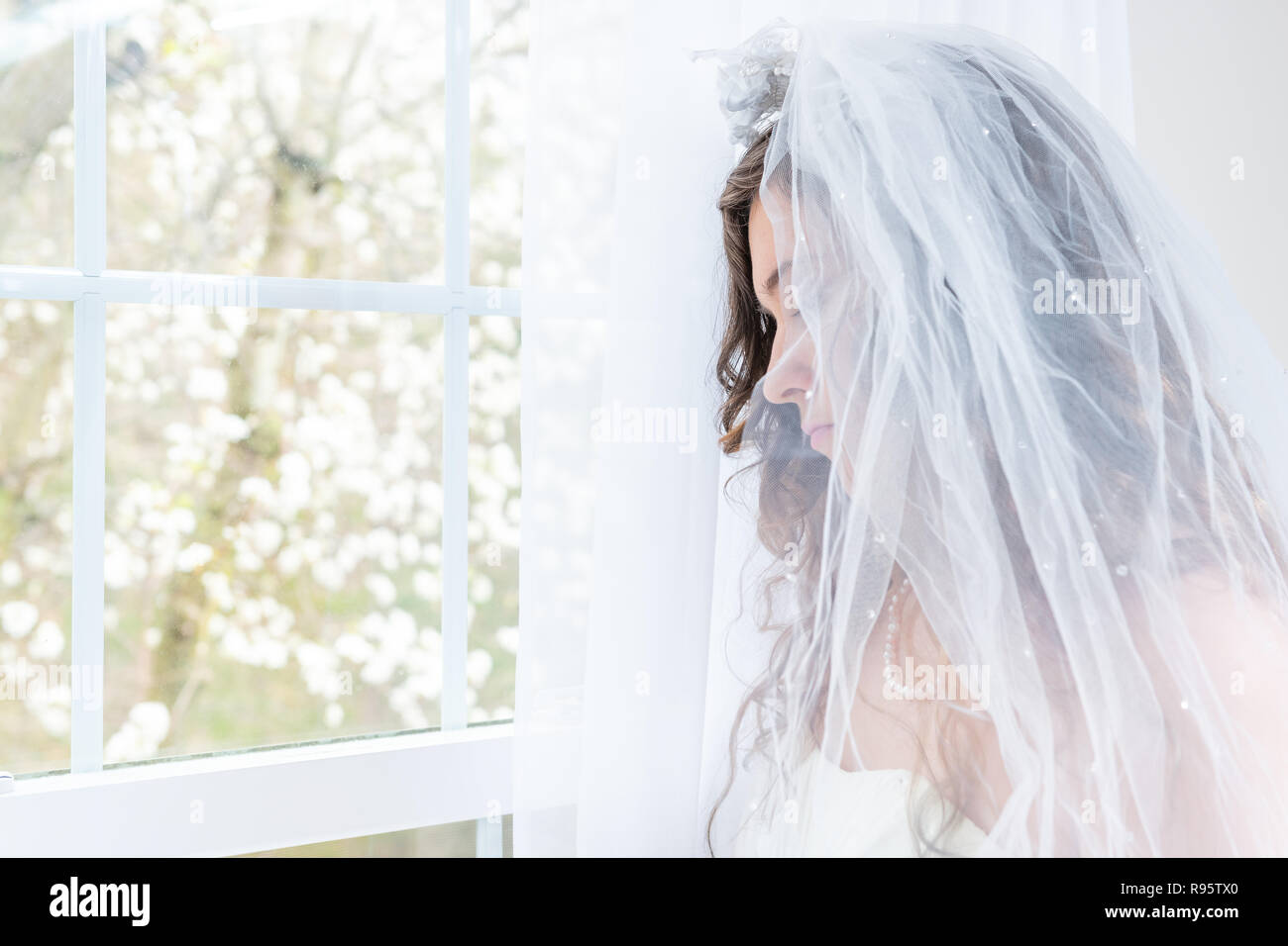 Côté gros plan, portrait de profil de jeunes personne de sexe féminin,  femme, mariée en robe de mariée, voile, le visage, collier de perles, les  cheveux, debout, regardant vers le bas, voir