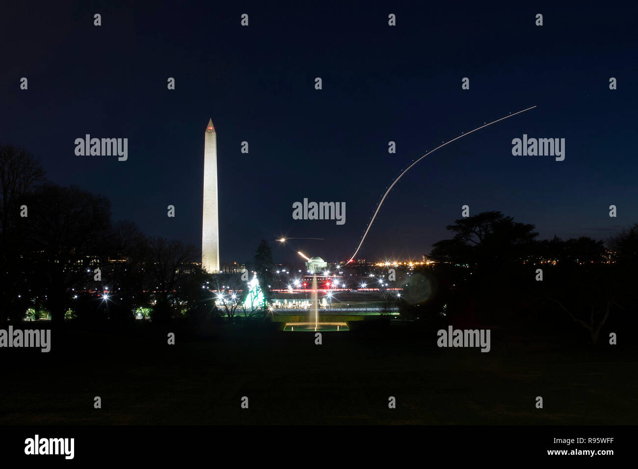 Vue sur le Washington Monument et National Mall à partir de la pelouse Sud de la Maison blanche décorée pour Noël et éclairée 12 décembre 2018 à Washington, DC. Les traces légères sont les avions décollant de l'Aéroport National Reagan sur la Rivière Potomac. Banque D'Images