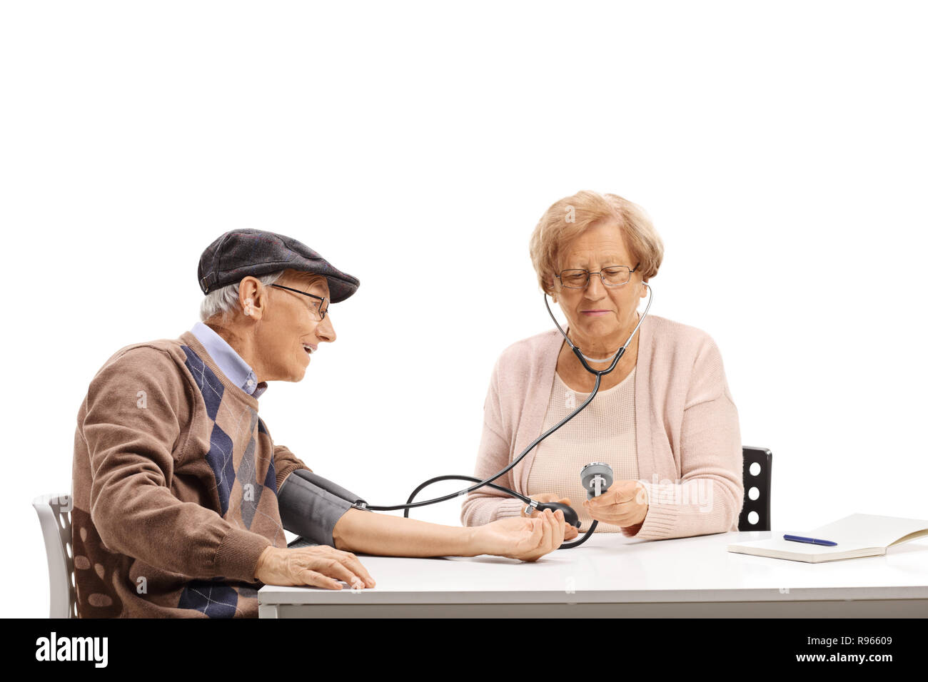 Femme âgée de prendre les mesures de la pression artérielle à son mari isolé sur fond blanc Banque D'Images