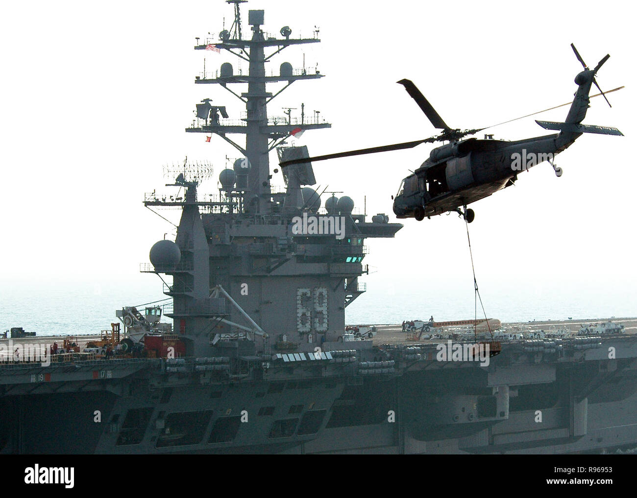 Un hélicoptère MH-60S Seahawk, affecté à la 'dragon' Les baleiniers de l'Escadron d'hélicoptères de combat de la mer deux huit (HSC-28), les transferts de munitions le poste de pilotage de la classe Nimitz porte-avions USS Dwight D. Eisenhower (CVN 69) lors d'un ravitaillement vertical (VERTREP) en mer. U.S. Navy photo by Miguel Angel Contreras Banque D'Images