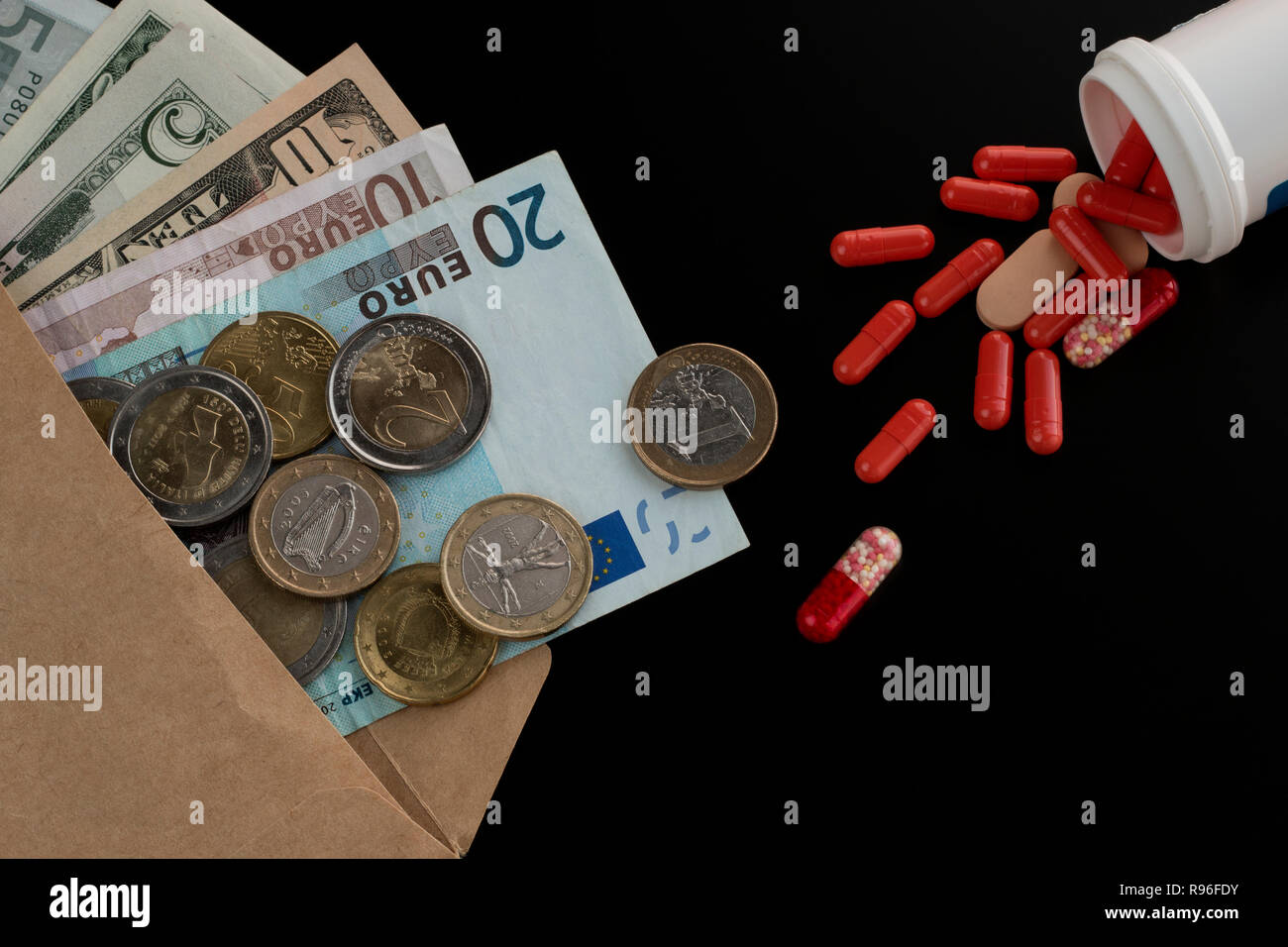 Euro et dollar monnaie dans l'enveloppe contre comprimés dispersés, pilules, gélules. Les frais médicaux, l'achat de médicaments Banque D'Images