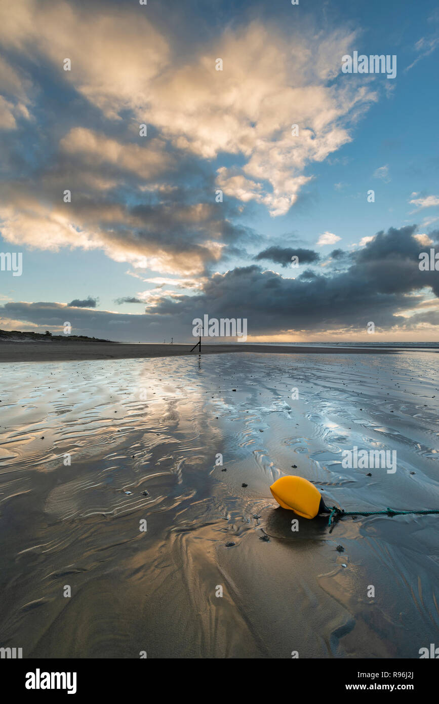 Beau lever de soleil sur l'hiver à l'Ouest Wittering beach dans le Sussex en Angleterre avec du vent qui souffle sur la plage de sable Banque D'Images