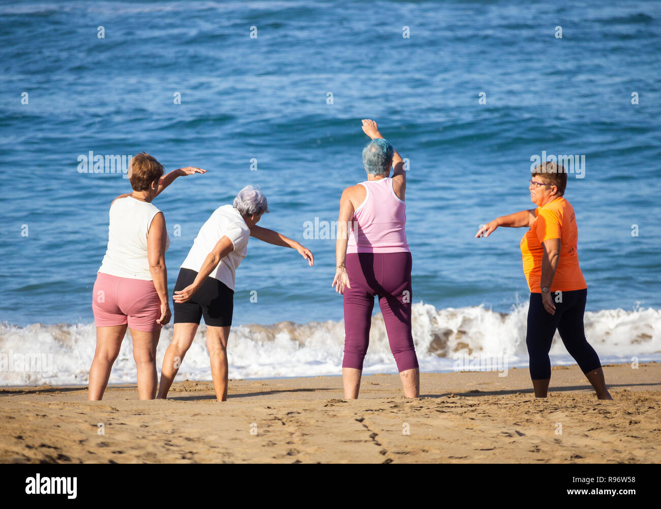 Les femmes âgées qui s'étend sur la plage en garder la forme class en Espagne Banque D'Images