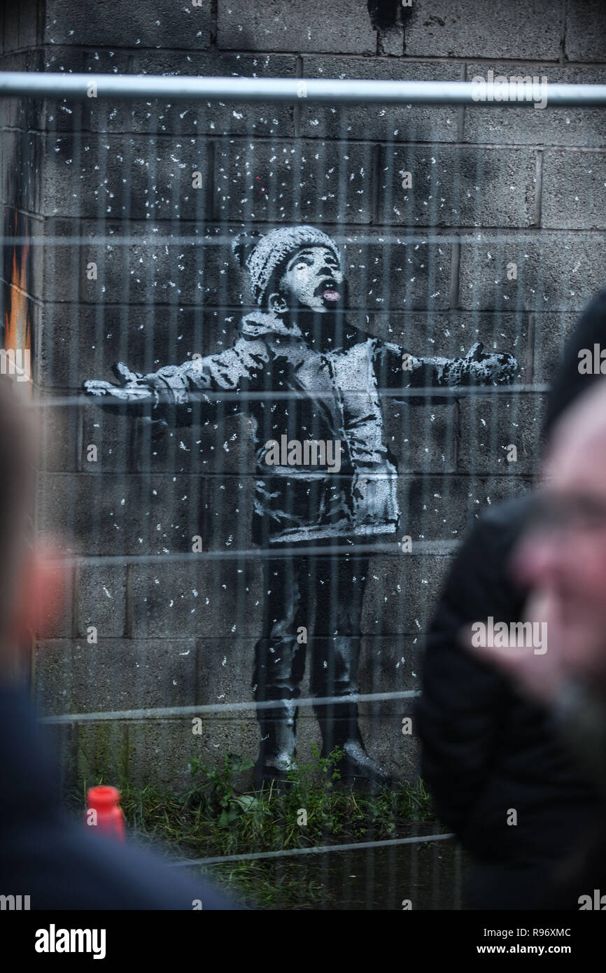 Port Talbot, Pays de Galles, Royaume-Uni. 20 décembre 2018. Les gens affluent à un garage dans la ville de l'acier de Port Talbot, dans le sud du Pays de Galles, Royaume-Uni, après qu'il a été confirmé qu'un travail de l'écriture graffiti figurant sur elle, a été produit par l'artiste Banksy. L'illustration montre un enfant avec les bras en l'air, être couverts par ce qui semble être de la neige, mais est en fait, les cendres provenant de la combustion d'une poubelle, peint de l'autre côté du garage coin. L'artiste de renommée mondiale, il a été confirmé son travail via son compte instagram. Crédit photo : Robert Melen/Alamy Live News Banque D'Images