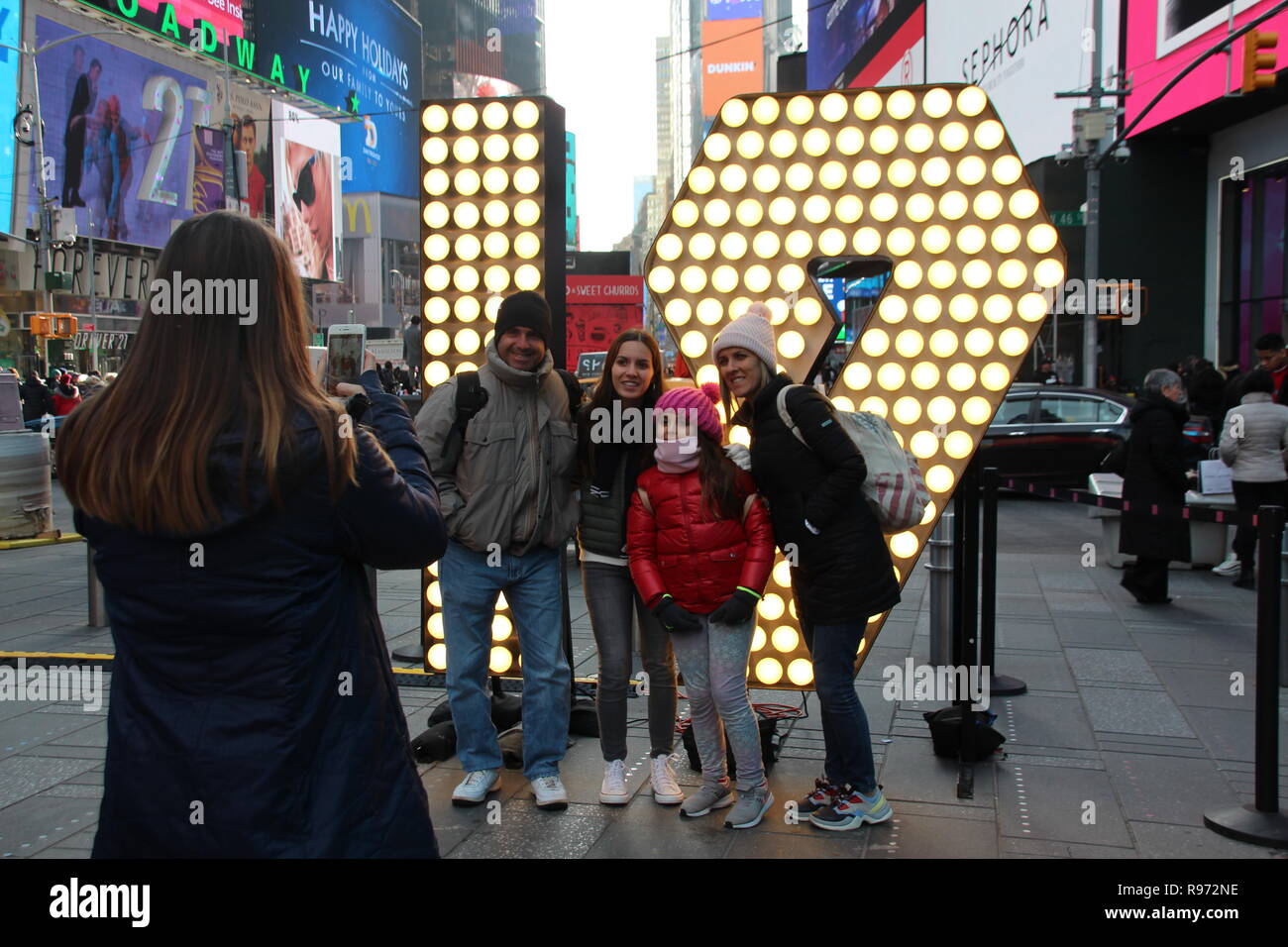 New York, USA. Dec 19, 2018. Visiteurs en ligne Times Square en face de l'allumé 19 pour une photo. Dans les prochains jours, les chiffres sont d'être hissé à bord, ainsi qu'une tour afin de former la nouvelle année 2019 avec la '2' et '0'. (Dpa ''19' : Times Square se prépare pour Silvesterspektakel' à partir de 20.12.2018) Crédit : Christina Horsten/dpa/Alamy Live News Banque D'Images