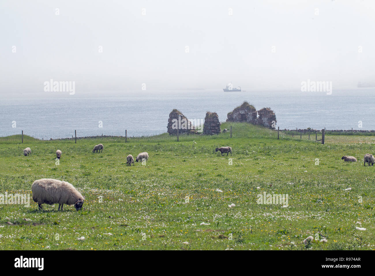 Brume sur la mer le son d'Iona, de l'île d'Iona, à l'Est, vers les îles de Mull, obscurci et enveloppée de brouillard. Le bâtiment en pierre d'un Diseirt Cladh reste sur l'île d'Iona.​The Hébrides intérieures. L'Écosse.​ Banque D'Images