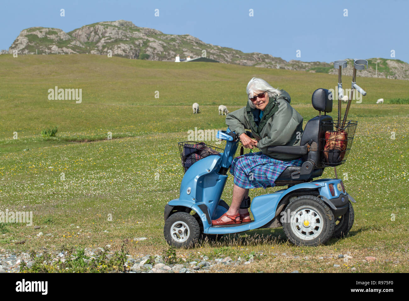 ​​Disabled. Handicap physique. Pao. Une femme âgée, de conduire un véhicule électrique à quatre roues agréable donnant l'indépendance et l'accès à la scène rurale, campagne et de l'environnement en général. Iona. Les Hébrides intérieures. L'Argyll and Bute, Ecosse.​ Banque D'Images