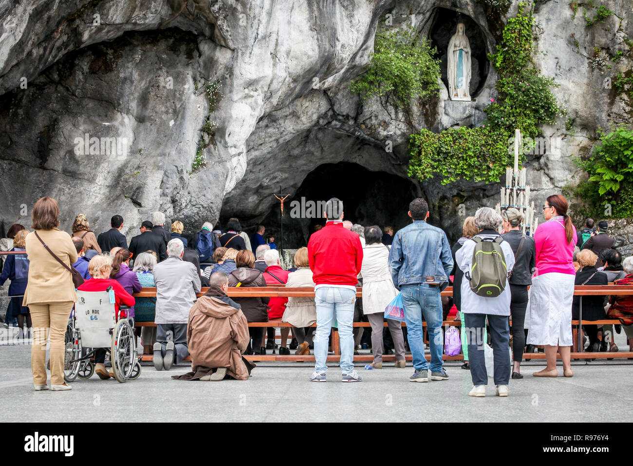 Pèlerinage à la grotte de Massabielle à Lourdes (sud-ouest de la France). C'est là que la Vierge Marie est apparue 18 fois à Bernadette Soubirous en 1858 et où elle a découvert une source qui coule dans la grotte possédant des vertus miraculeuses. (Pèlerins malades et en bonne santé) visiter la grotte. Banque D'Images