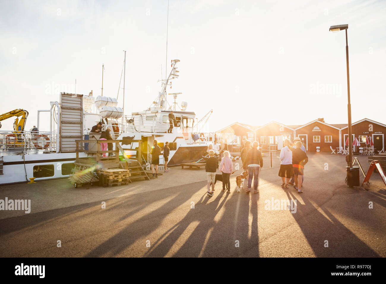 Les gens qui marchent au coucher du soleil au port de Hano en Suède Banque D'Images