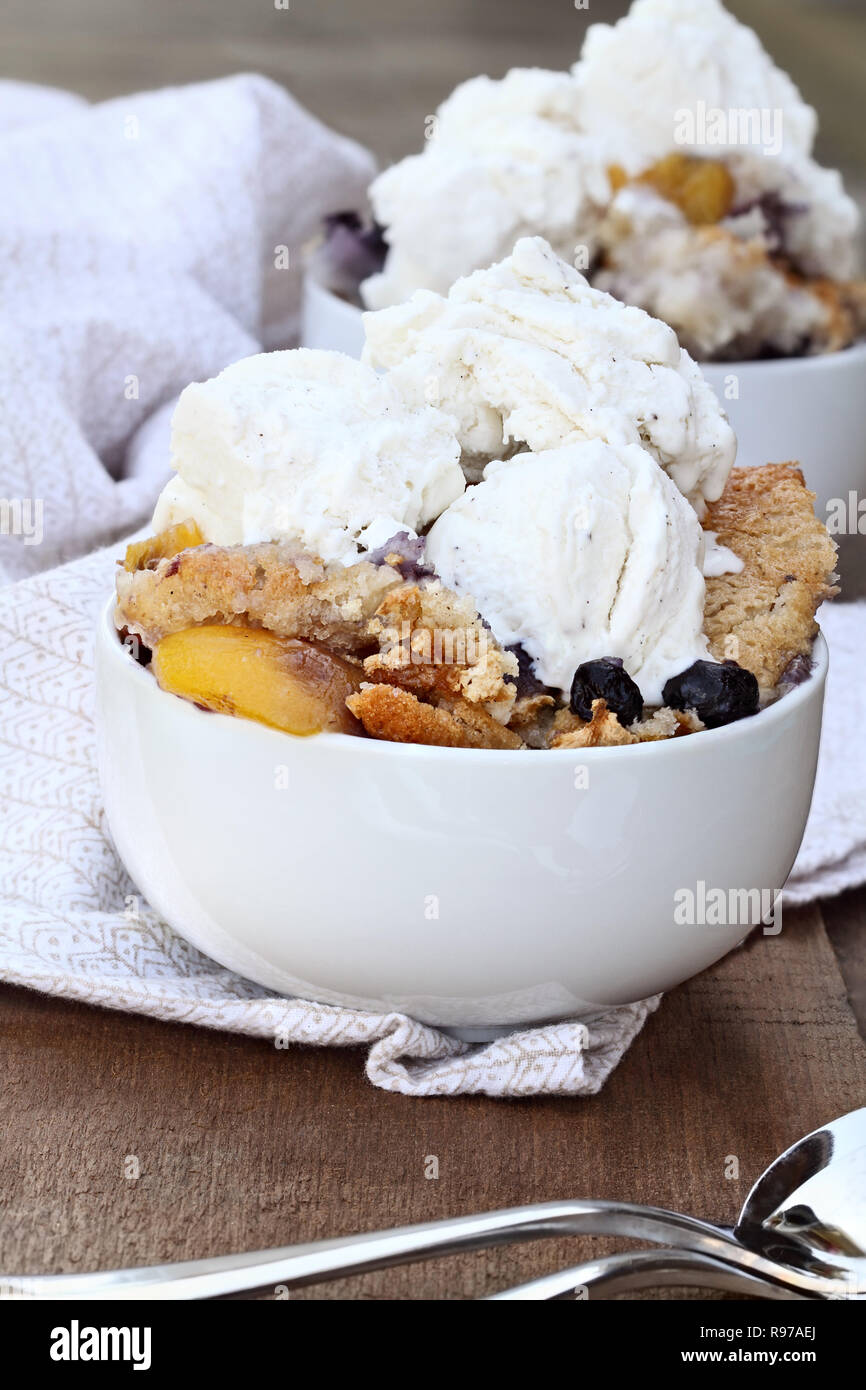 Fresh peach cobbler aux bleuets et servi avec de la glace à la vanille. Profondeur de champ avec focus sélectif. Banque D'Images