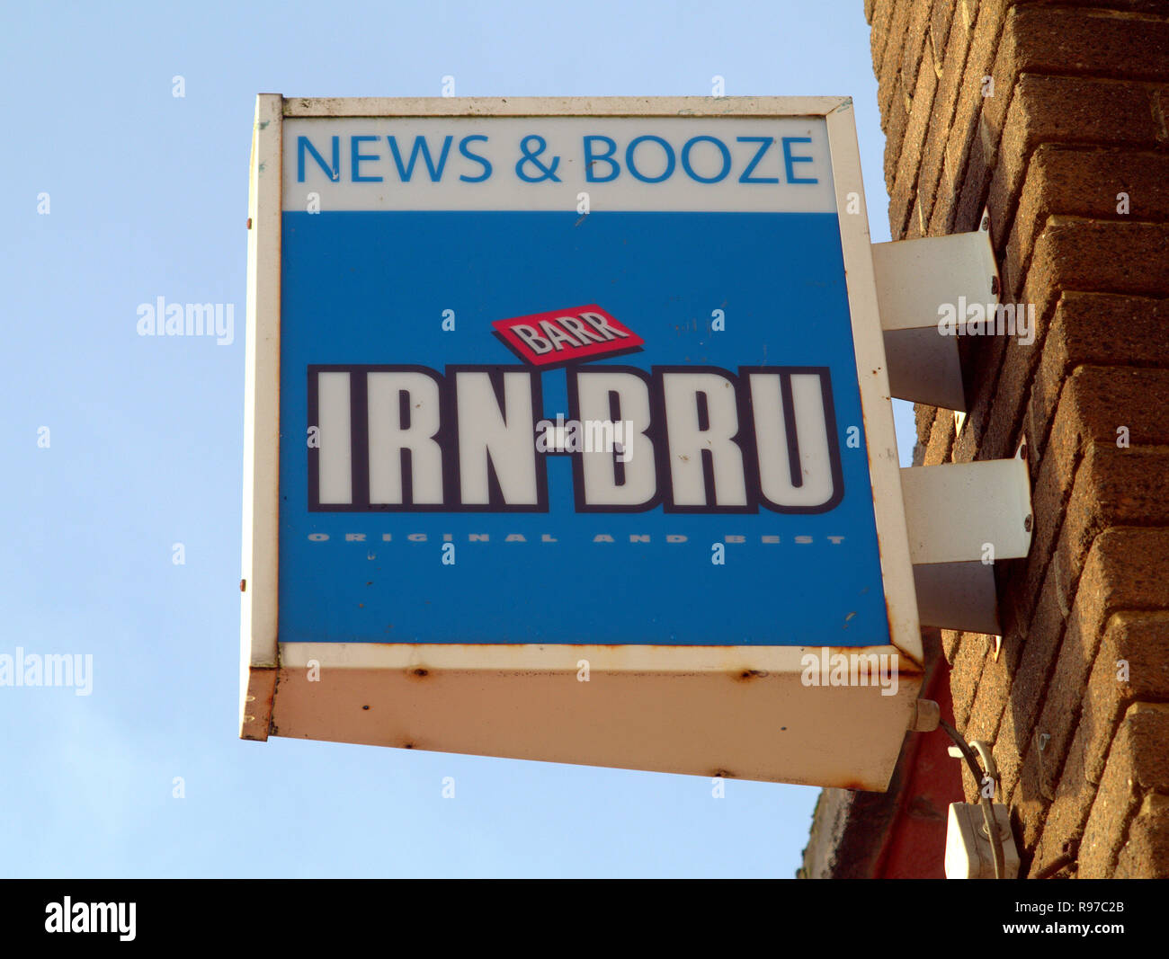 Marchand de panneau publicitaire pour irn bru IRN-BRU pour un magasin appelé news et booze ciel bleu Banque D'Images