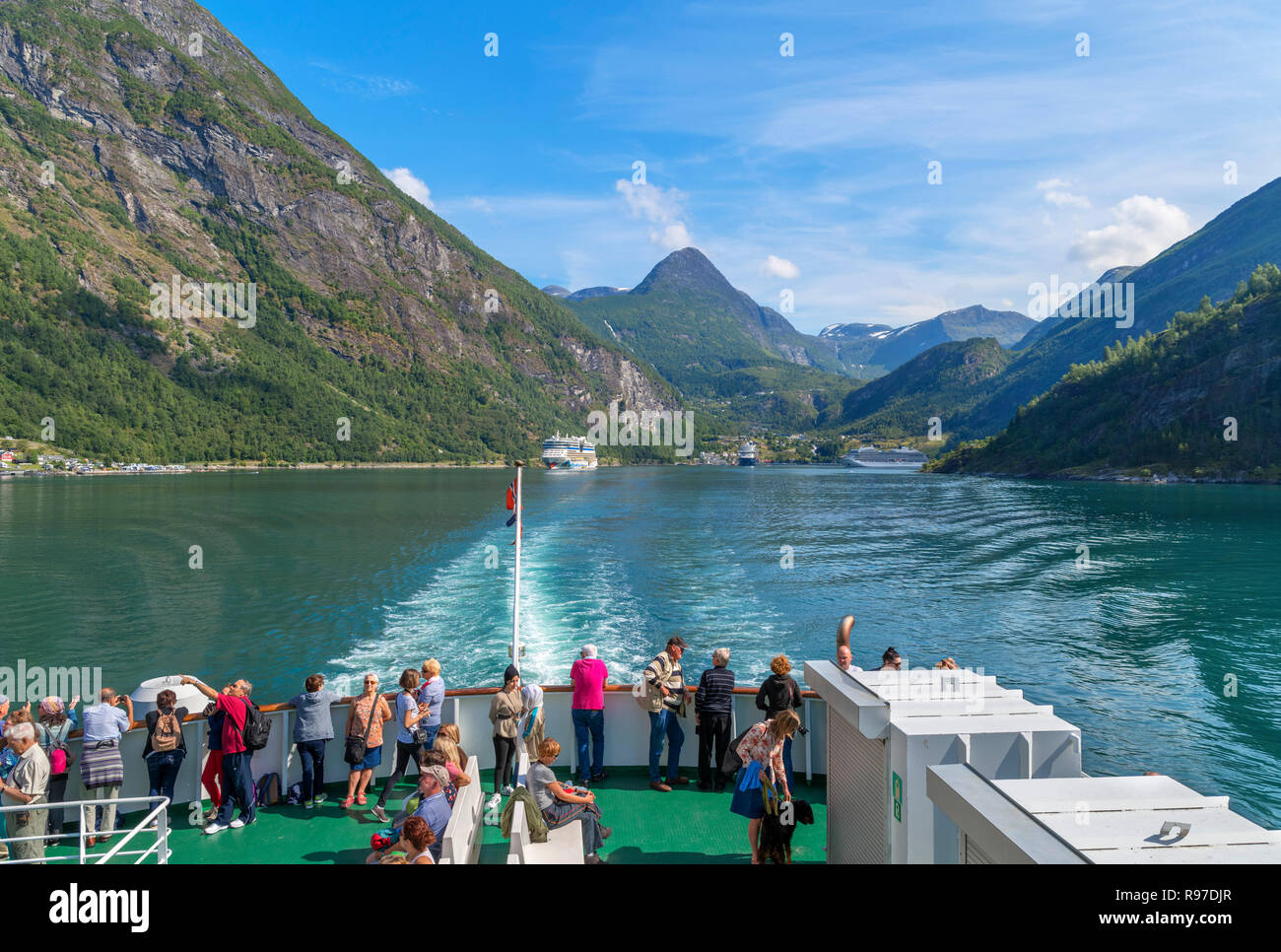 Les touristes sur le pont du ferry Hellesylt à Geiranger regarder en arrière vers la ville de Geiranger, Geirangerfjord, Norvège Banque D'Images