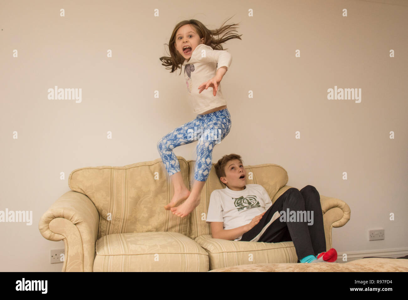 Les enfants, frère et soeur à propos de saut sur des meubles, de la plongée et de sauter, d'être hyperactifs, beaucoup d'énergie, de jouer ensemble Banque D'Images