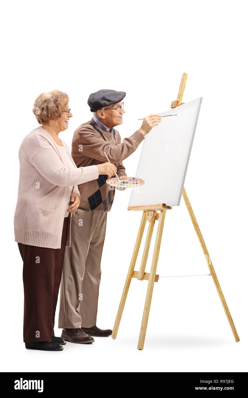 Tourné sur toute la longueur d'un couple de personnes âgées de l'homme et de la femme avec des brosses de peinture sur une toile isolé sur fond blanc Banque D'Images