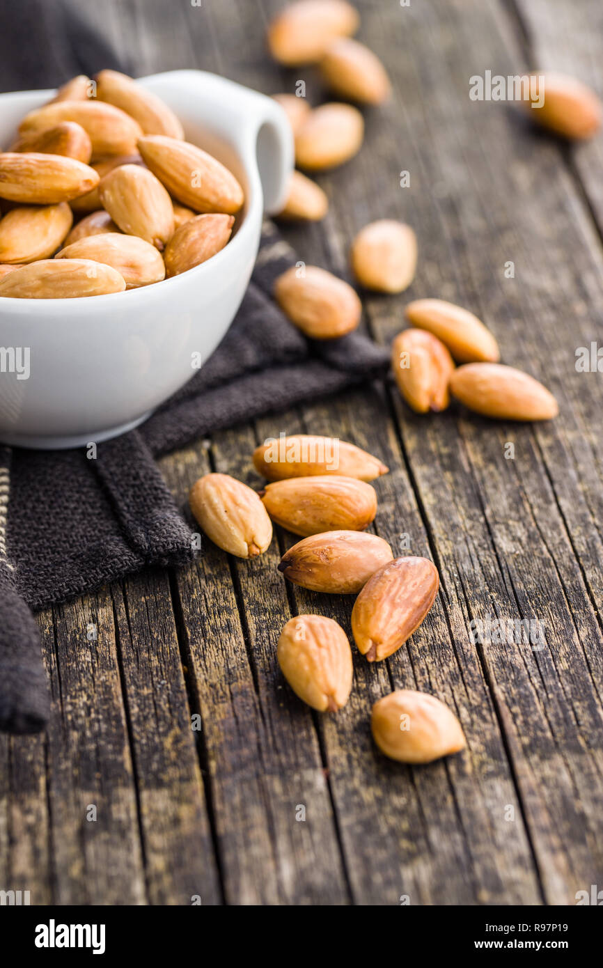 Salé amandes rôties sur la vieille table en bois. Banque D'Images