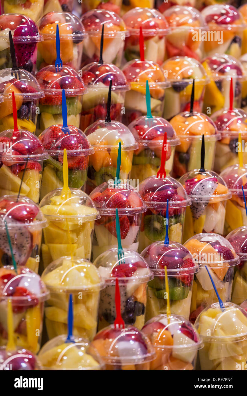 Diverses sortes de fruits frais dans des gobelets en plastique pour la préparation de boissons smoothie. Boire des boissons fruitées et colorées. Banque D'Images