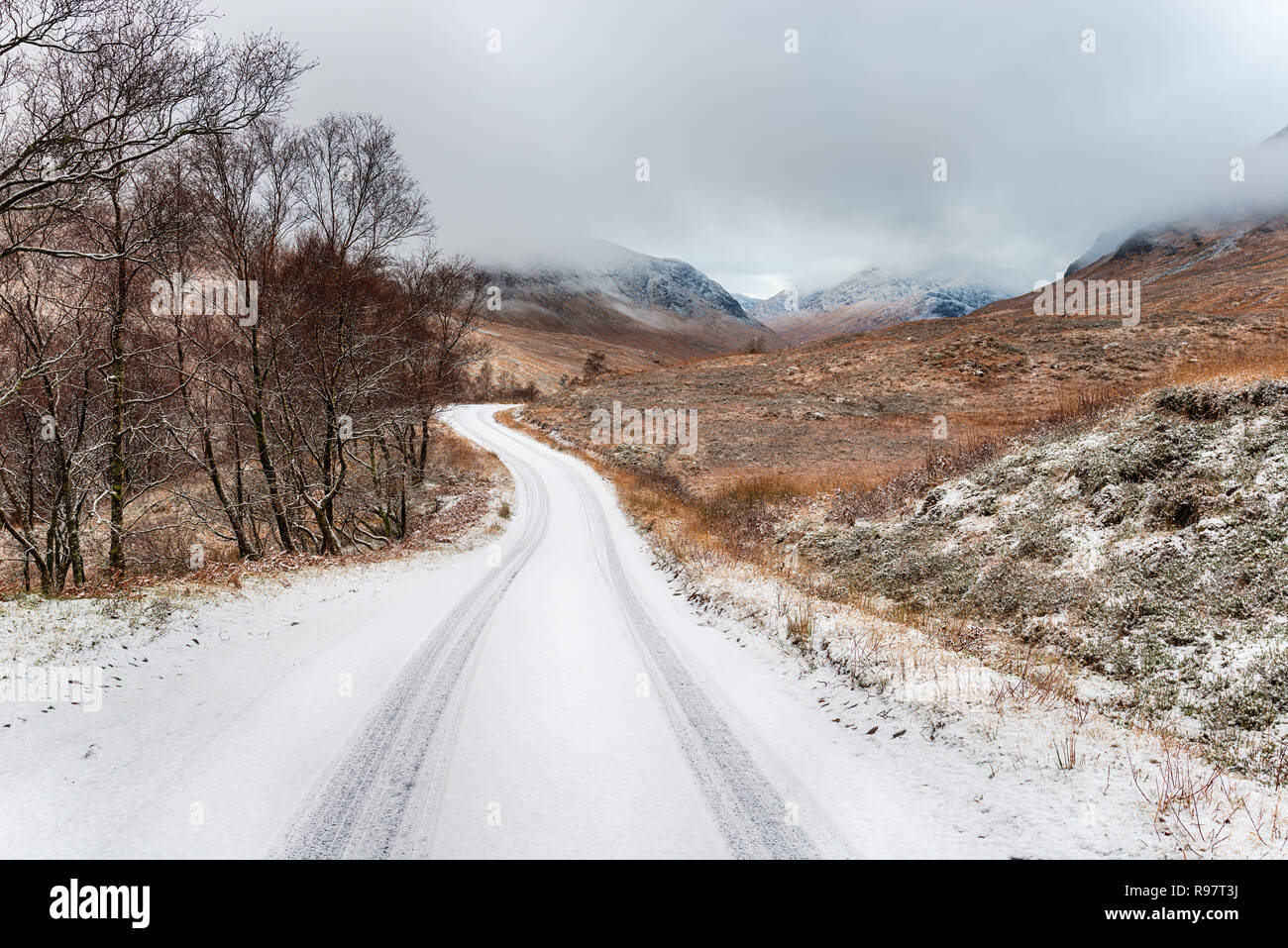 La route qui traverse Glen Etive à Glencoe dans les montagnes de l'Ecosse après une mince couche de neige Banque D'Images