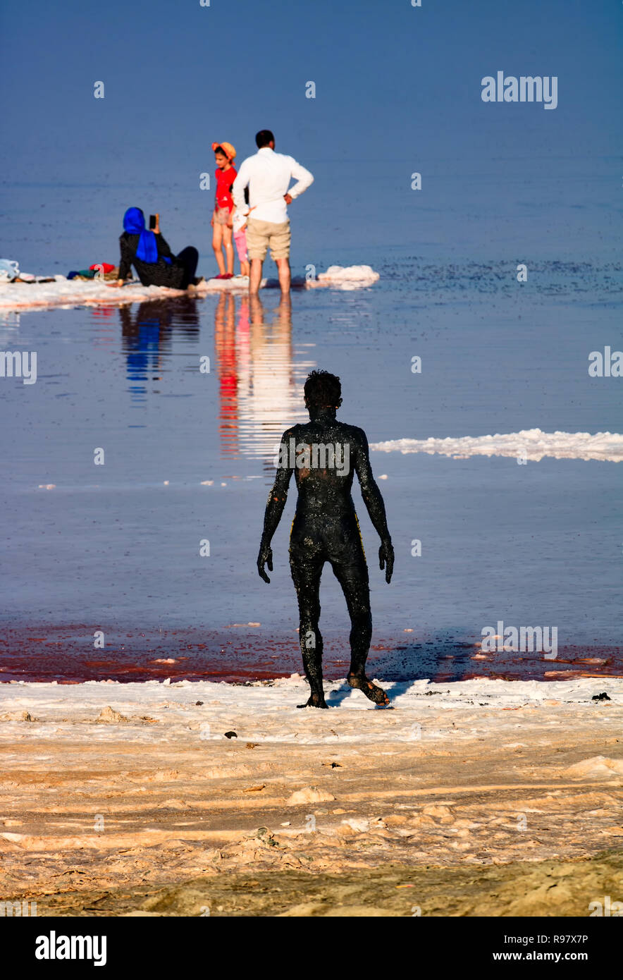 Le lac d'orumieh-manteaux un homme lui-même dans la boue noire au lac d'Orumieh, un lac salé dans la province de l'Azerbaïdjan. Banque D'Images Le lac d'orumieh-manteaux un homme lui-même dans la boue noire au lac d'Orumieh, un lac salé dans la province de l'Azerbaïdjan. Banque D'Images