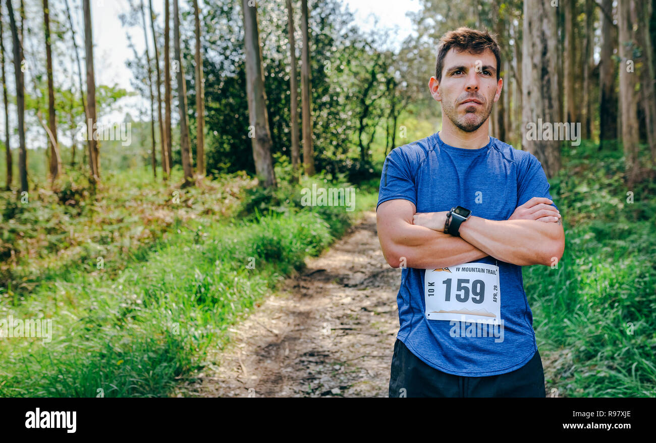 Athlète masculin trail posant avec numéro de course Banque D'Images