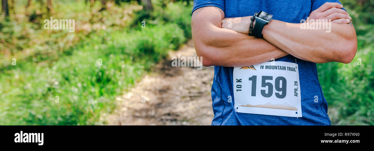 Athlète masculin trail posant avec numéro de course Banque D'Images