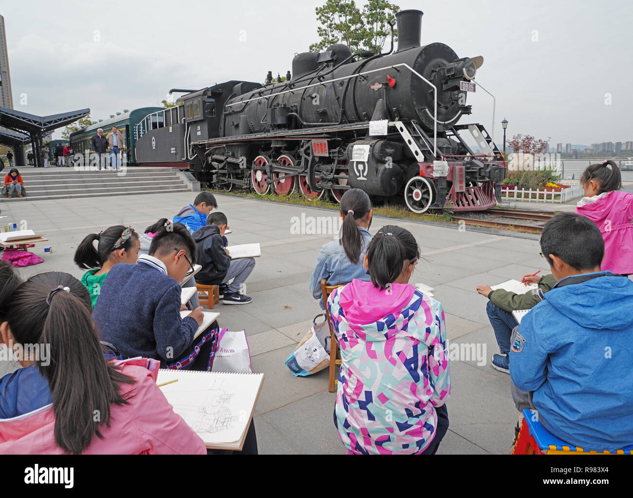 Les enfants de l'école dessin locomotive à vapeur le long du parc de la rivière Yangtze, à Nanjing, Chine. Banque D'Images