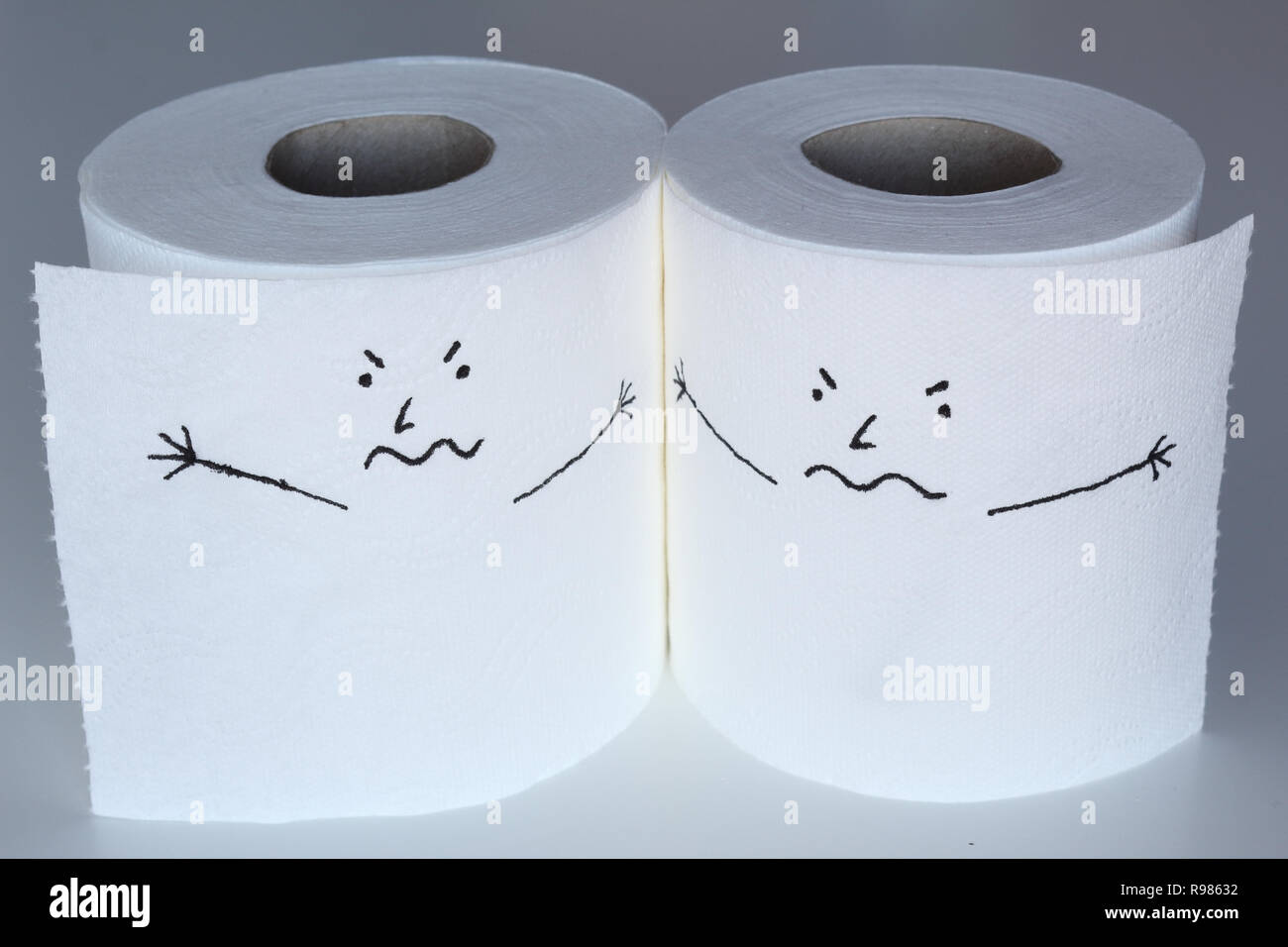 Deux rouleaux de papier toilette blanc esquissé avec caractères furieux proches les uns des autres, avec un visage en colère, représentant les sentiments de rage Banque D'Images