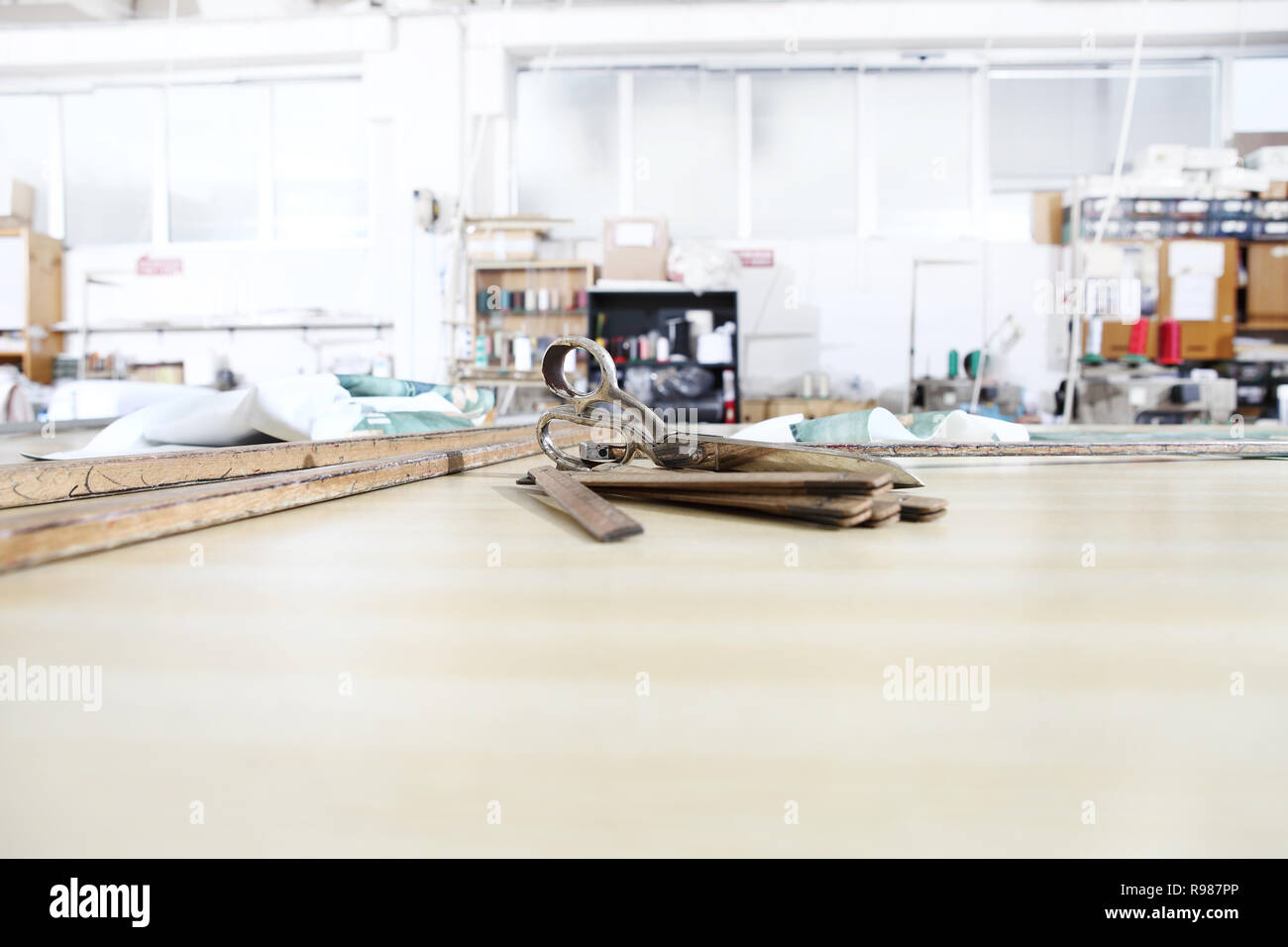 Outils du tailleur, de vieux ciseaux, mètre en bois et d'une règle sur l'art vestimentaire table de travail Banque D'Images
