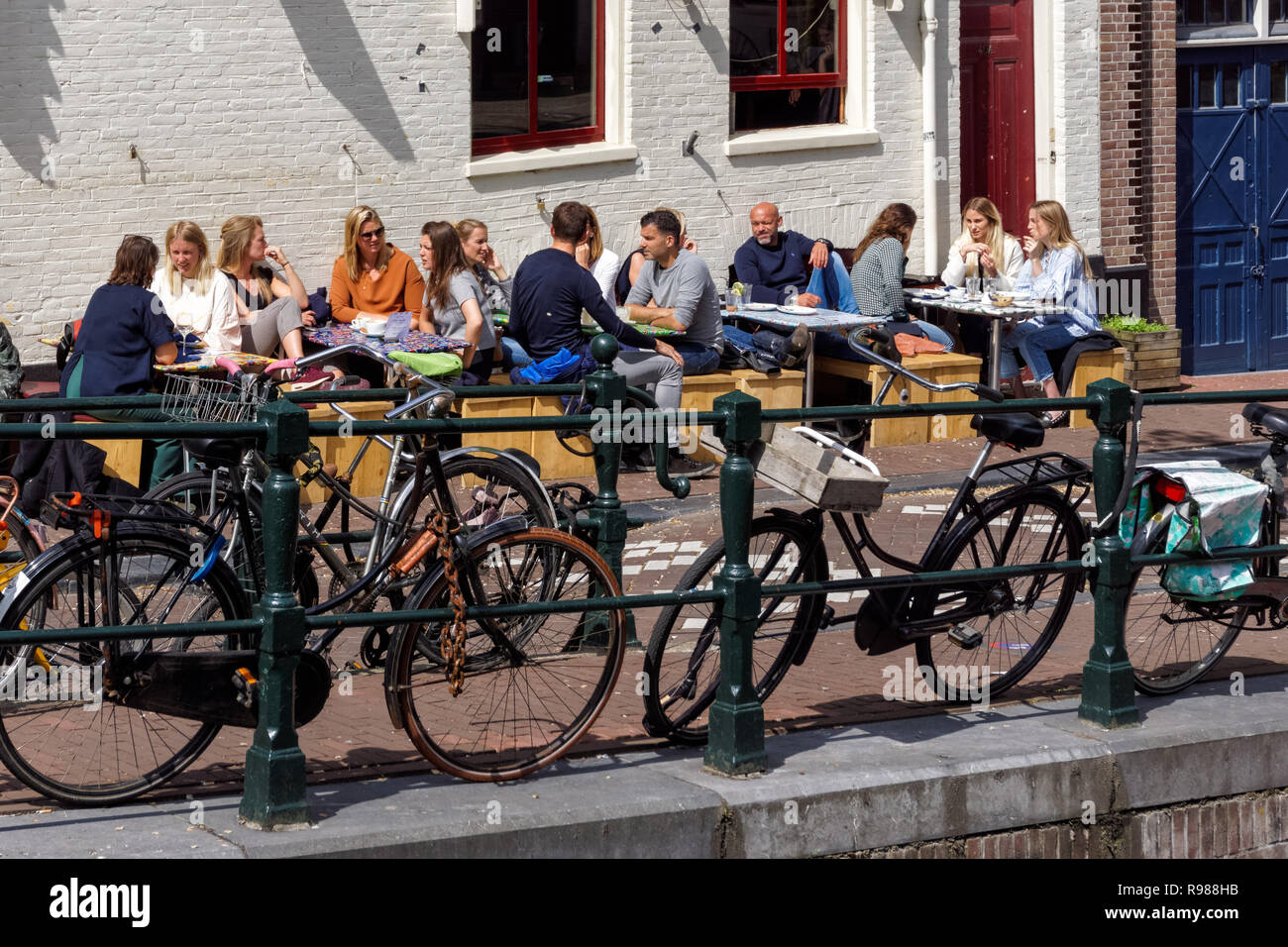 Les jeunes gens assis à l'extérieur de Festina Lente cafe à Amsterdam, Pays-Bas Banque D'Images