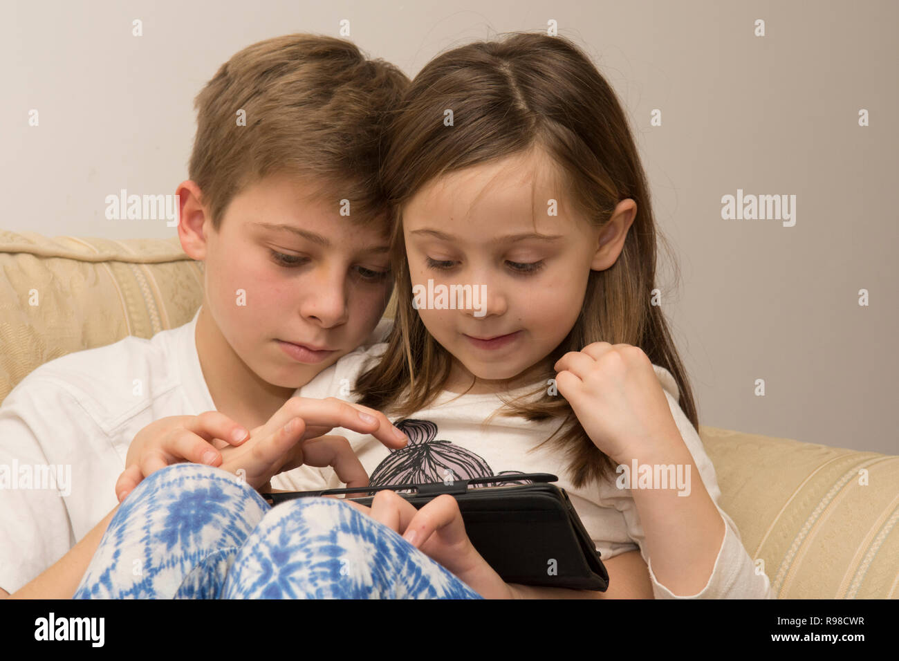 Appareil numérique, tablette, iPad, frère aîné d'aider sœur plus jeune avec les médias sociaux, la technologie moderne Banque D'Images