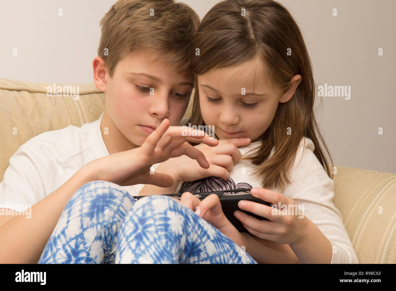 Appareil numérique, tablette, iPad, frère aîné d'aider sœur plus jeune avec les médias sociaux, la technologie moderne Banque D'Images