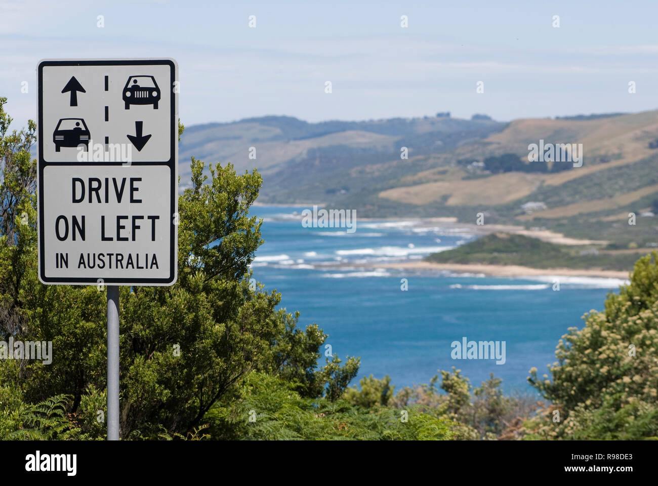 Conduire sur la gauche, un symbole attention le long d'une route côtière en Australie Banque D'Images